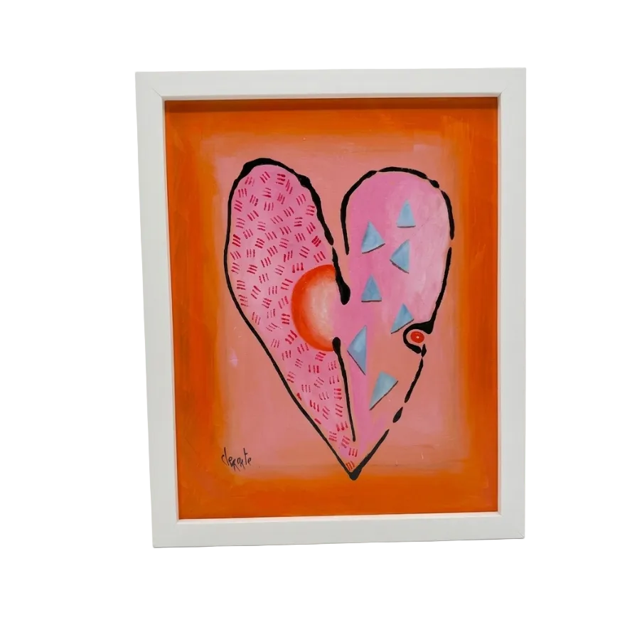 Framed artwork of a pink heart with blue triangles on an orange background