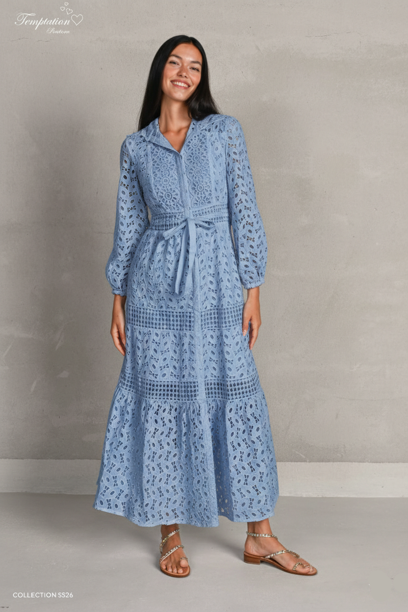 Woman wearing a blue lace dress against a plain background