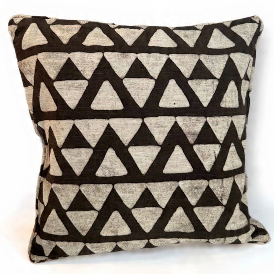 Decorative pillow with black triangle pattern on a beige background