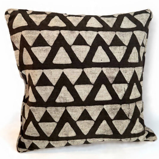 Decorative pillow with black triangle pattern on a beige background