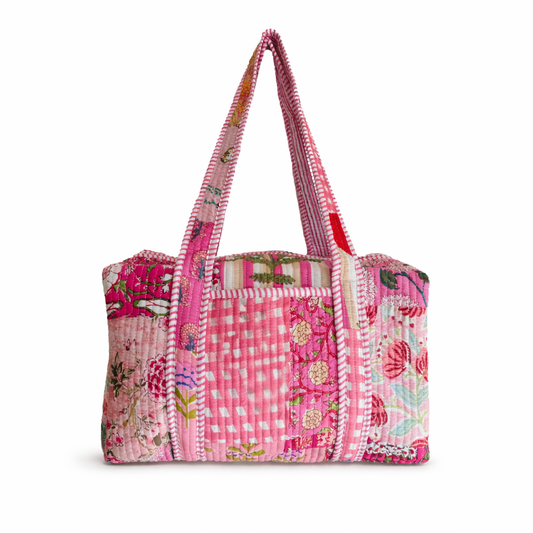 Pink patchwork tote bag with floral and checkered patterns on a white background