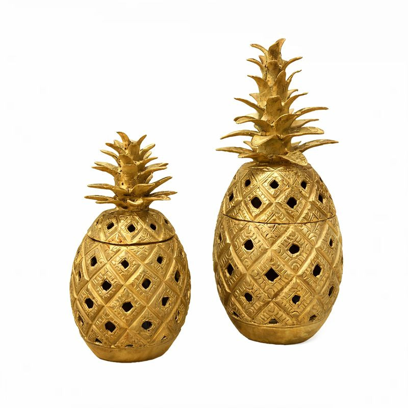 Two gold pineapple-shaped decorative jars on a white background