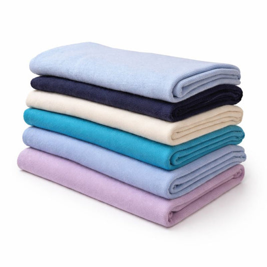 Stack of folded cashmere wraps  in various colors on a white background