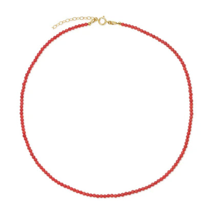 Red coral beaded necklace with a gold clasp on a white background