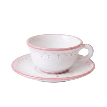 A white ceramic teacup and saucer set with delicate pink decorative borders, shown on a clean white background.