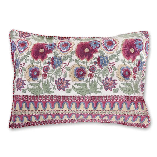 A square decorative throw pillow with a cream background, featuring a vibrant floral pattern in purple, blue, and green, and a textured geometric border in pink and gold along the bottom.