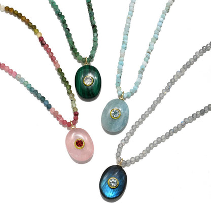 Four necklaces with colorful bead strands and various gemstone pendants on a white background