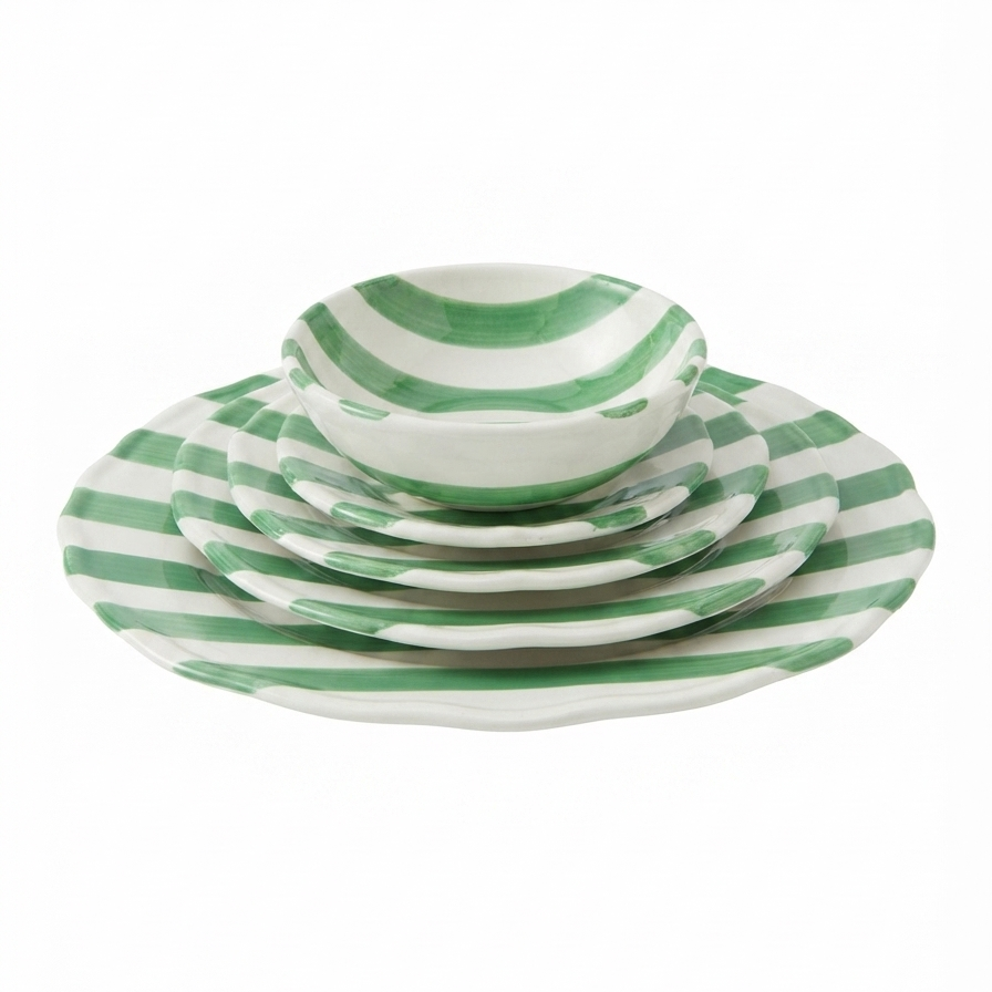 A set of green and white striped ceramic dinnerware, including a large platter, plates, and a small bowl, stacked on a plain white background.