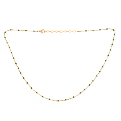 Gold necklace with green beads on a white background