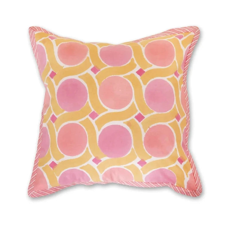 A square throw pillow with a pink and yellow geometric pattern, featuring a pink rope fringe along the edges, shown against a plain white background.