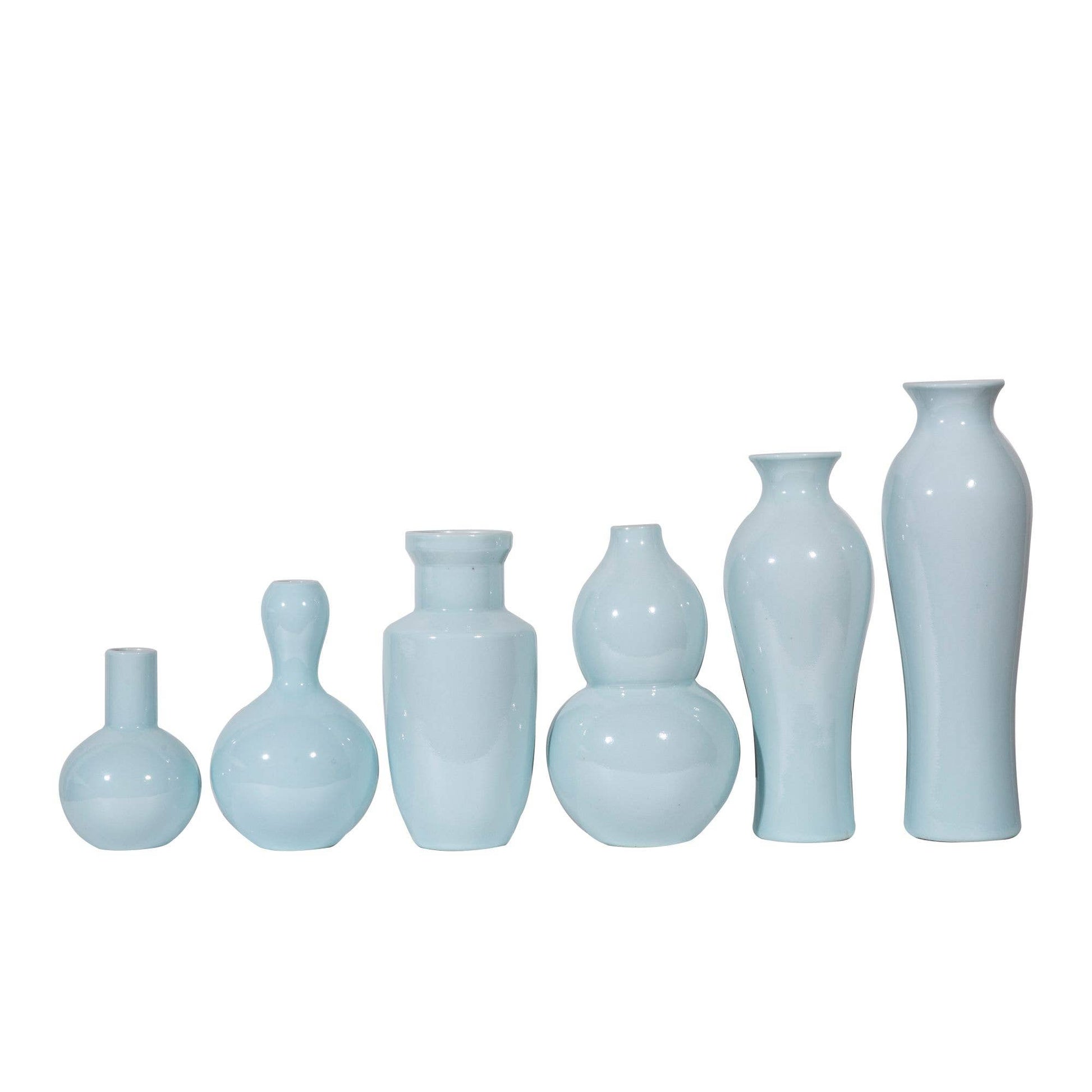 Set of light blue ceramic vases of various shapes on a white background