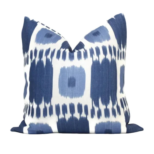 A square throw pillow featuring a blue and white ikat pattern, photographed against a clean white background.