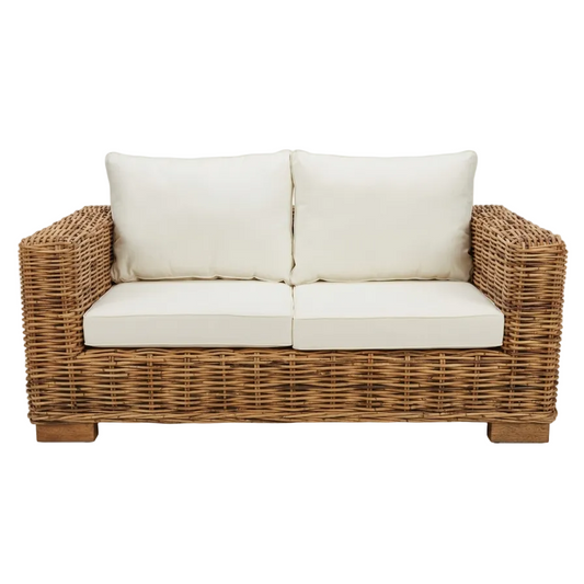 Wicker loveseat with white cushions on a white background