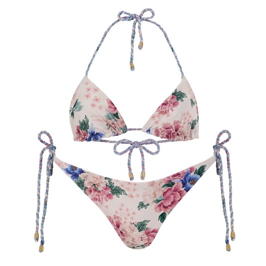 A two-piece string bikini set with a pink and blue floral print on a cream background, featuring braided tie straps with gold bead accents.