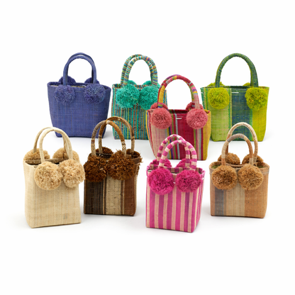 Colorful handbags with pom-pom details on a white background
