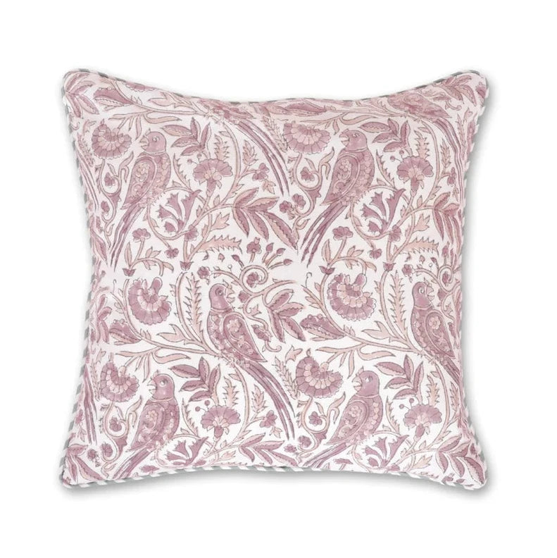 A square decorative throw pillow featuring a dusty pink and white botanical and bird pattern, shown against a plain white background with a blue brand logo in the top-left corner.