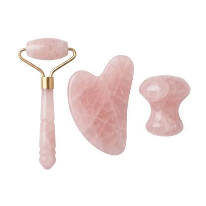 Three pink stone facial massage tools with gold-tone metal accents, including a roller, a gua sha blade, and a smaller textured piece, arranged on a clean white background.