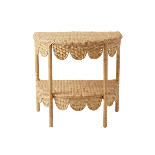 Wicker side table with scalloped edge design on a white background