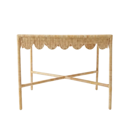 Woven rattan console table with scalloped edge on a white background