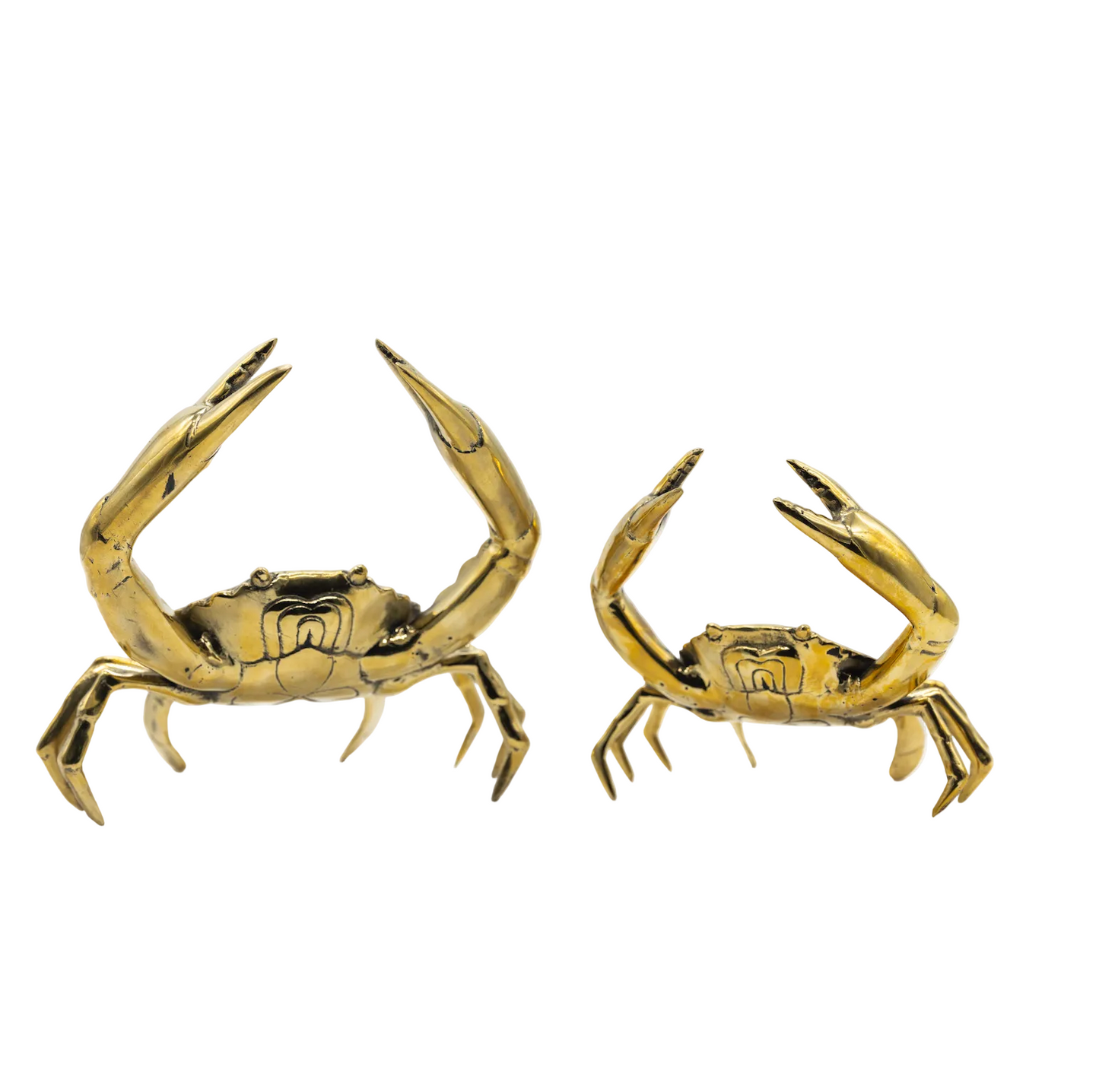 Two gold crab-shaped candle holders on a white background
