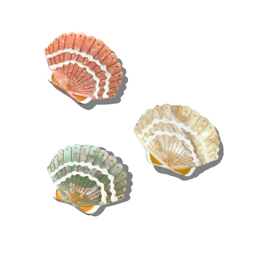 Three seashell haircuts of different colors on a white background