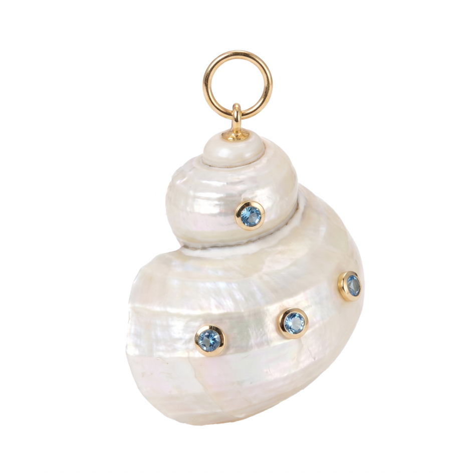 A spiral shell pendant charm made of white mother-of-pearl with small round blue gemstones set in gold, featuring a gold ring loop at the top, shown on a plain white background.