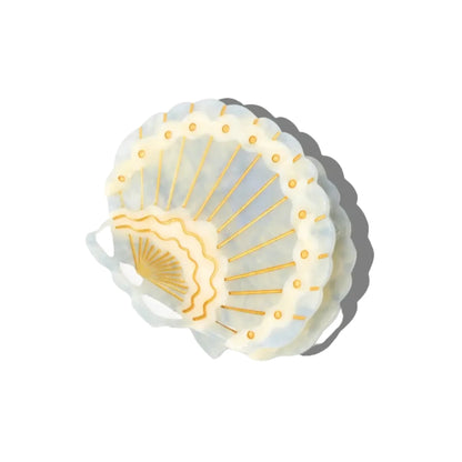 Shell-shaped hair clip with gold accents on a white background